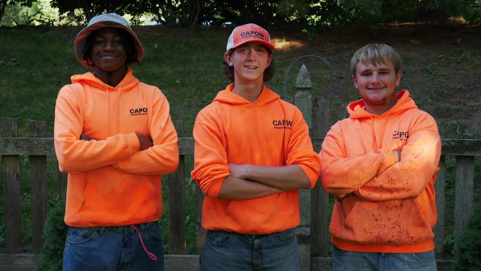 Jackson, Caleb and Mathew from CaPow Pressure Washing in their orange CaPow hoodies